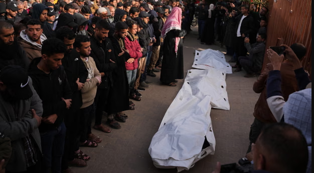 ប្រជាជនហ្កាហ្សា ឈរជុំវិញសាកសពម្នាក់ដែលស្លាប់ដោយសារអ៊ីស្រាអែលវាយប្រហារ។