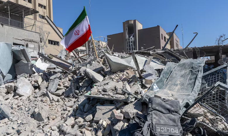 ទង់ជាតិអ៊ីរ៉ង់ដោតលើគំនរអគារបែកបាក់ដោយសារការវាយប្រហារពីអាម៉េរិក-អ៊ីស្រាអែល។